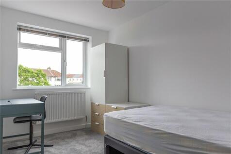 A clean and simple single bedroom featuring a l...