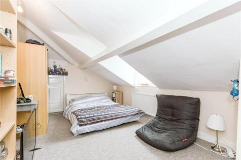 A cozy double bedroom with a sloped ceiling and...