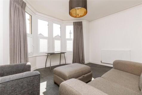 A cozy living room featuring ample natural ligh...