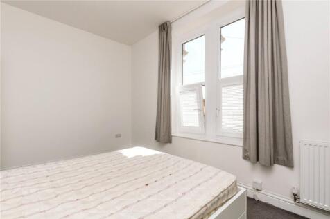 Bright double bedroom featuring a large window ...