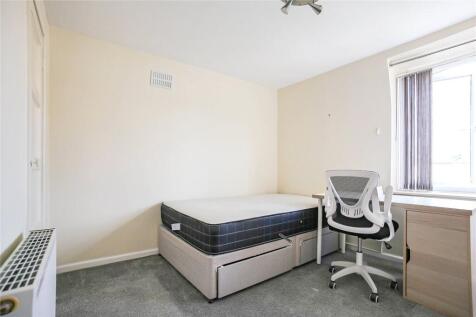 A clean and simple bedroom featuring a single b...