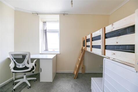 A bright and tidy single bedroom featuring a wo...