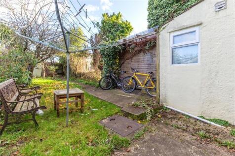 A charming garden space featuring a grassy area...