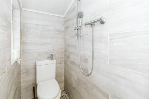 A modern, clean single toilet room featuring el...