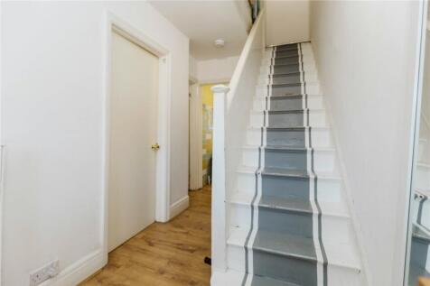 A bright and clean hallway featuring light wood...