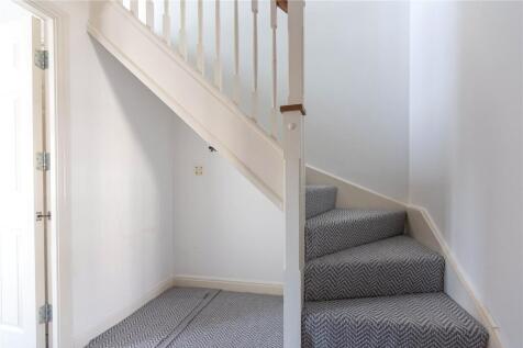 A clean and modern carpeted staircase area with...