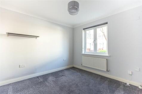 A clean and bright small room featuring a windo...