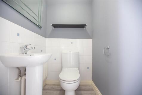 A clean and simple single toilet with a white c...