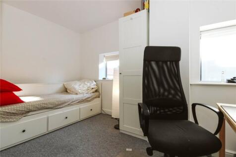 A neat and functional single bedroom featuring ...