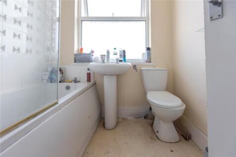 A bright bathroom suite featuring a bathtub wit...