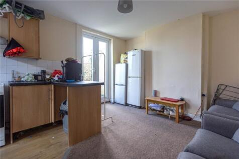 A cozy living room featuring a compact kitchen ...