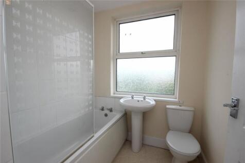 A clean and bright bathroom featuring a white b...