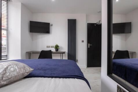 This modern double bedroom features a cozy bed ...