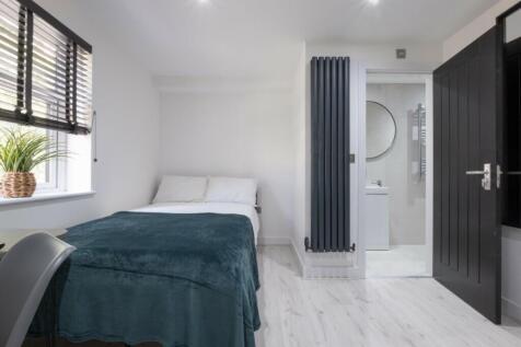 A stylish double bedroom featuring a cozy bed w...