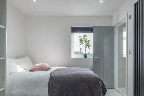 This inviting double bedroom features a cozy at...