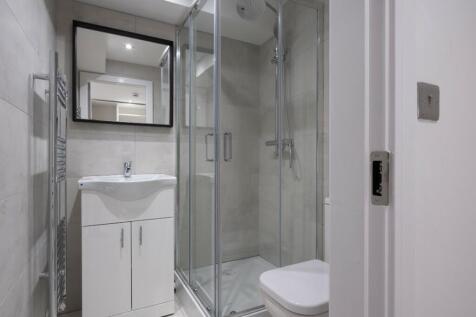 A modern bathroom featuring a stylish glass sho...