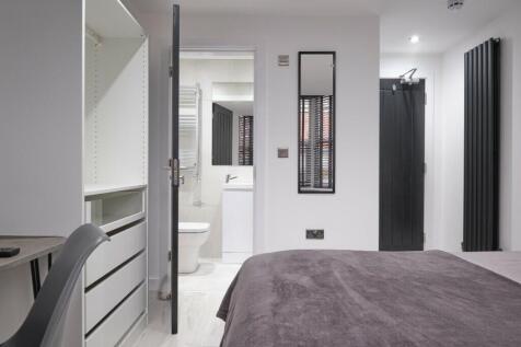 A modern and tidy double bedroom featuring ampl...