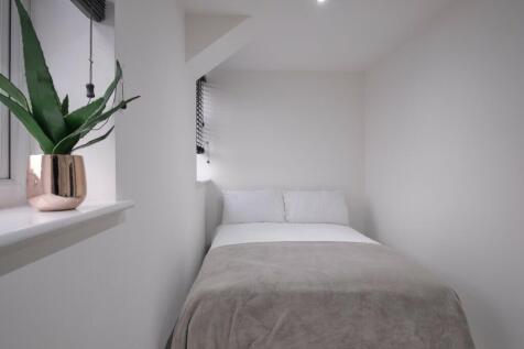A bright and clean double bedroom featuring a c...