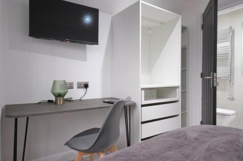 A modern and tidy double bedroom featuring a de...