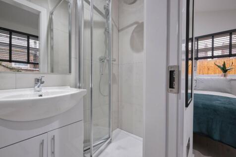 A modern and well-lit bathroom featuring a slee...
