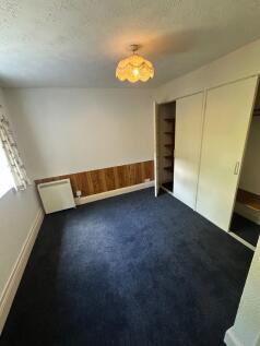 Cozy single bedroom featuring a large window wi...