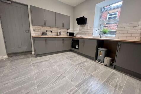 Modern kitchen featuring sleek grey cabinets, s...