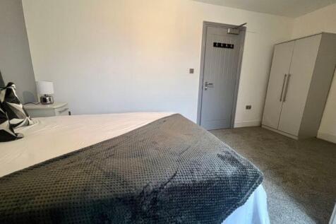 A clean and cozy double bedroom featuring a com...