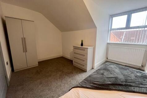 A cozy double bedroom featuring a large window ...