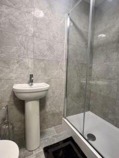A modern bathroom featuring sleek grey tiled wa...