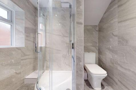 A modern bathroom suite featuring a sleek glass...