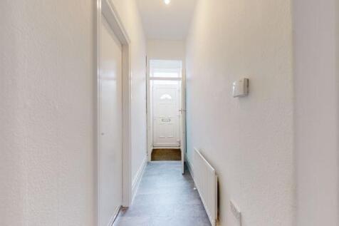 A clean and bright hallway with smooth white wa...