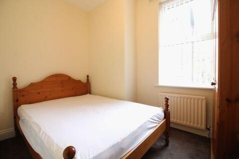 A cozy double bedroom featuring a wooden framed...