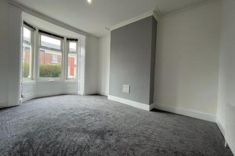A spacious master bedroom featuring a large bay...