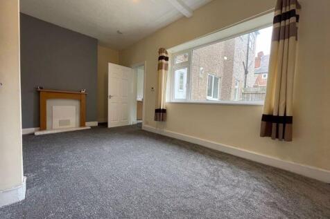 A charming living room with fresh carpeting, a ...