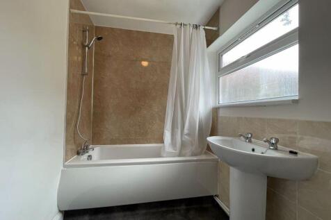 Bright and clean bathroom suite featuring a ful...