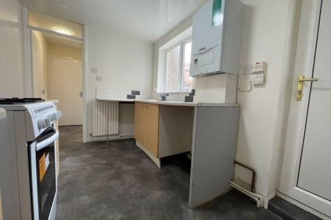 A bright kitchen featuring a gas stove, a count...