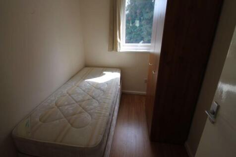A compact single bedroom featuring a simple mat...