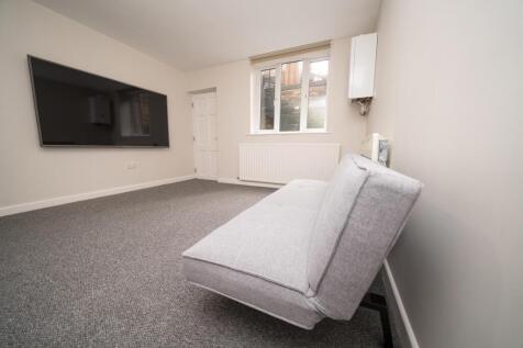 A clean and modern living room featuring a wall...