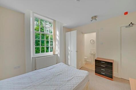 Bright master bedroom featuring a large window ...