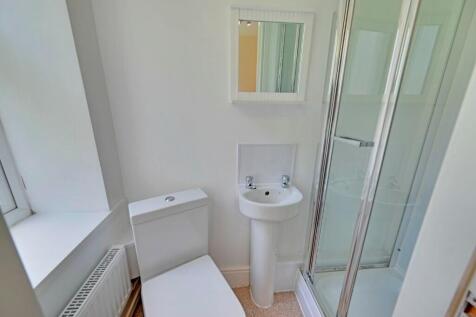 A modern bathroom featuring a compact white toi...