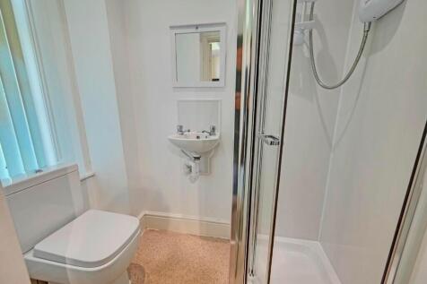 A clean and modern bathroom featuring a glass-e...