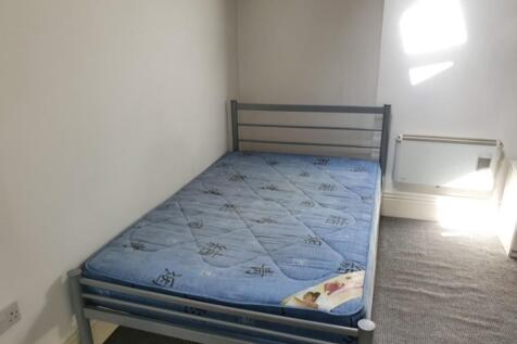 A simple, neat single bedroom featuring a metal...
