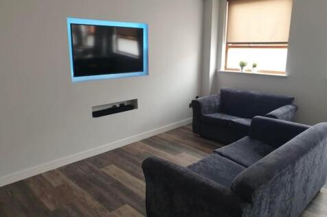 A modern living room featuring dark upholstered...