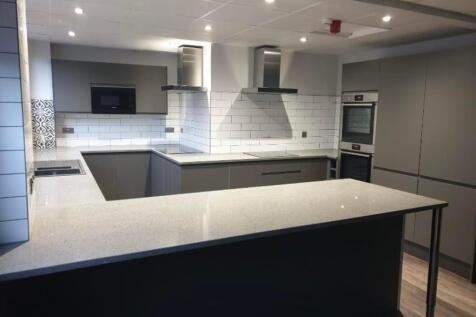 A modern kitchen featuring sleek grey cabinetry...