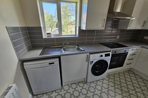 Bright and modern kitchen featuring a large win...