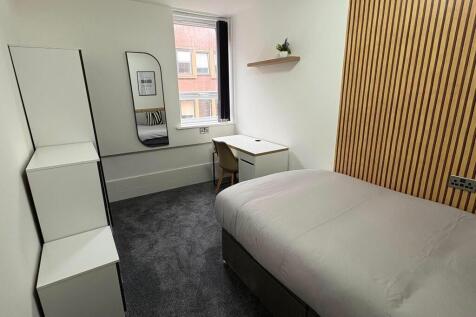 A modern and neatly arranged single bedroom fea...