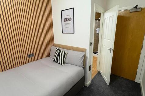 A cozy and modern single bedroom featuring a st...