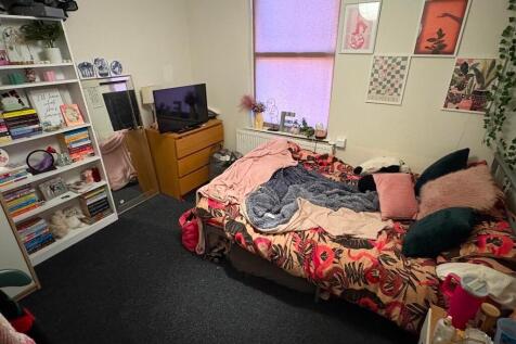 Cozy single bedroom with a colorful bedspread, ...