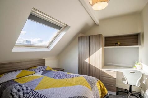 Bright and cozy master bedroom featuring a comf...