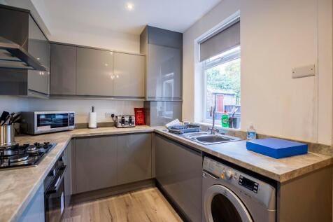 Modern kitchen featuring sleek grey cabinetry, ...